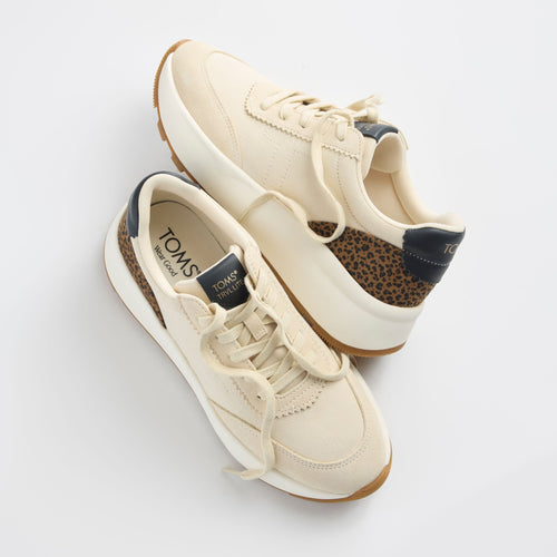 Laydown detail image of the ivory and leopard TRVL Lite wedge sneaker